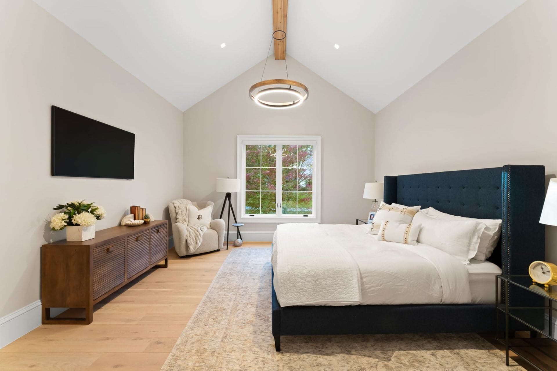 Guest bedroom with navy headboard and vaulted ceiling