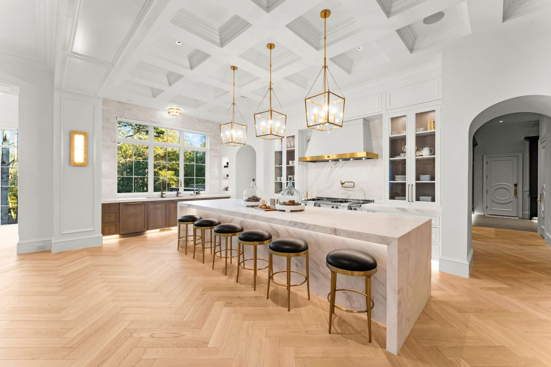 Kitchen island with marble waterfall and gold stools