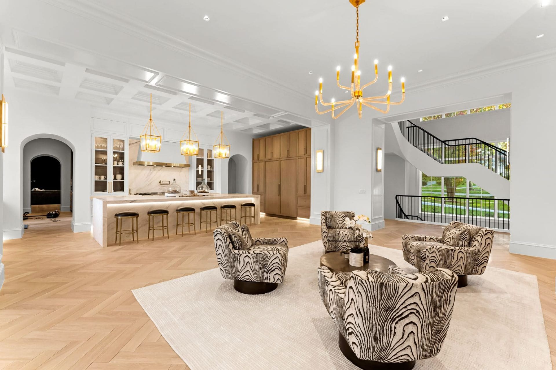 Open living and kitchen with staircase and gold chandelier